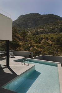 una piscina en la parte superior de un edificio con una montaña en Aposperia Memorable Living, en Kyra Panagia