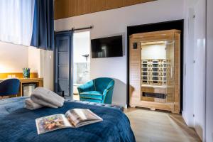 a bedroom with a blue bed with a book on it at Vespri Luxury Rooms & Suites in Palermo