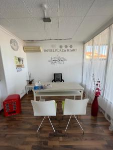 a white table and two white chairs in a room at Hotel Plaza Miami - Sólo Adultos in Miami Platja