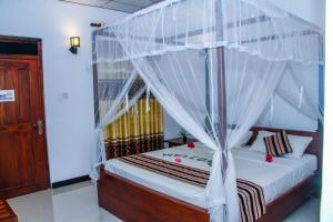 a bedroom with a bed with a canopy at Nimsara Lodge Sigiriya in Sigiriya