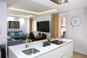 uma cozinha e sala de estar com um lavatório e um sofá em Piso Reformado a 2 Min del Casco Viejo Con Garaje Gratis em Bilbao