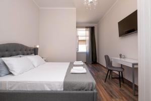 a bedroom with a bed with a desk and a chair at Dante paradiso in Pula