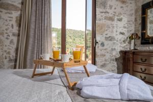Villa Sunshine Crete في Vathiakón: صينية خشبية مع مشروبات على سرير مع نافذة