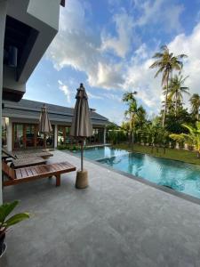 an outdoor patio with a pool and an umbrella at Baan Yaimai Boutique Samui in Bophut