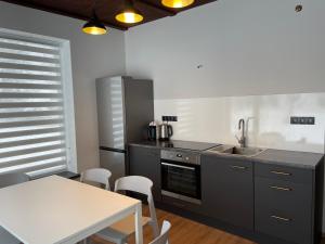 a kitchen with a sink and a table with chairs at Vasarnīca in Pļaviņas