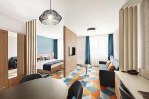 a hotel room with a bed and a living room at Hotel Europa Fit Hévíz in Hévíz
