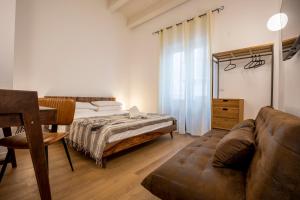 Vespri Apartments في باليرمو: غرفة معيشة مع سرير وأريكة