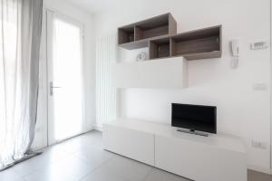uma sala de estar com televisão numa parede branca em Finisterrae 2 em Lido di Jesolo