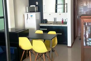uma cozinha com uma mesa preta e cadeiras amarelas em Cobertura Loft-Jacuzzi-Piscina-Praias-Super Vista em Niterói
