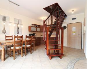 une cuisine et une salle à manger avec un escalier en colimaçon en bois dans l'établissement Apartament Korona Królów Świnoujście, à Świnoujście