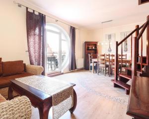 a living room with a table and a dining room at Apartament Korona Królów Świnoujście in Świnoujście