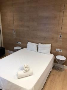 a bedroom with a large white bed with two chairs at Lovely Apartament in Málaga