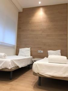 a room with two beds and a wooden wall at Lovely Apartament in Málaga