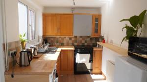 a kitchen with wooden cabinets and a stove top oven at Portallo Peace: a sanctuary in the city. in Belfast