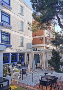 un patio con mesas y sombrillas frente a un edificio en La Posada de El Chaflán, en Madrid