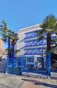 una puerta azul frente a un edificio con palmeras en La Posada de El Chaflán, en Madrid