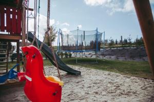 einen Spielplatz mit Rutsche und Schaukel in der Unterkunft Wilczarz in Duszniki-Zdrój