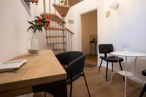 ein Zimmer mit Stühlen und einem Tisch mit einer Blumenvase in der Unterkunft Vespri Apartments in Palermo + 38 Fotos