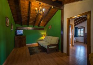 a living room with green walls and a couch at CASA RURAL ETXANO in Amorebieta-Etxano