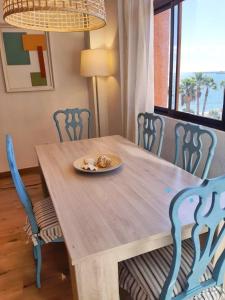 a wooden table with chairs and a plate of food on it at Panoramic views to the sea in Malaga in Málaga
