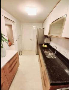 a kitchen with a sink and a refrigerator at Apto paraíso praia dos anjos in Arraial do Cabo