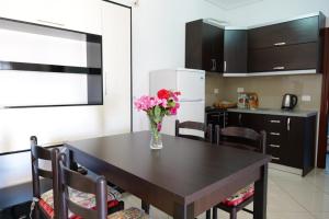 卡萨米尔Vila Ervin Ksamil的厨房里有一张桌子，桌子上放着一瓶花