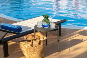 een tafel met een vaas erop naast een zwembad bij Amalia Hotel Nafplio in Nafplio