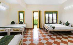 a bedroom with two beds and a checkered floor at Kokanwadi Resort in Ratnagiri