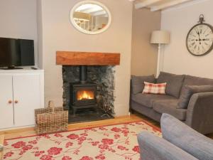 a living room with a couch and a fireplace at Clock cottage in Conwy