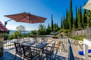 a table with chairs and an umbrella on a patio at Villa Mlin in Gruda