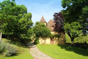 een oud huis met een tuin en een loopbrug bij Maison de 4 chambres avec piscine partagee et jardin amenage a Saint Cybranet in Saint-Cybranet