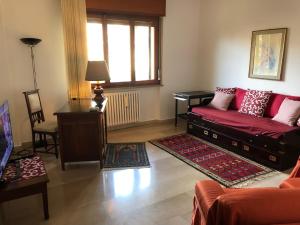 ein Wohnzimmer mit einem roten Sofa und einem Fenster in der Unterkunft La Pigna Verde in Taranto