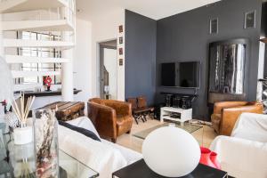 a living room with leather furniture and a tv at Appartement terrasse 3*dominant St Martin de Ré in Saint-Martin-de-Ré