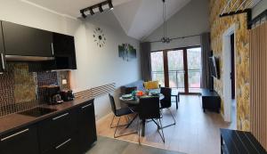 een keuken en een woonkamer met een tafel en stoelen bij Karpatia Resort Apartament Karbonado in Karpacz