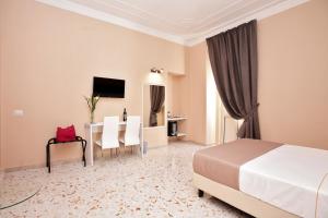 una camera d'albergo con letto, tavolo e sedie di "S. Cecilia" a Messina