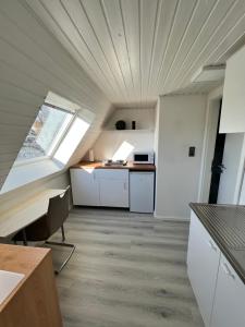 an attic kitchen with white cabinets and a ceiling at Waldblick in Herford