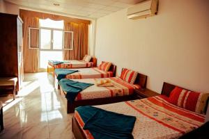 a room with four beds and a window at Station House in Dahab