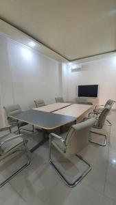 a conference room with a table and chairs and a screen at Grand Puri Hotel in Nusa Penida