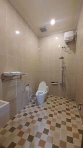 La salle de bains est pourvue de toilettes et d'un sol en damier. dans l'établissement Grand Puri Hotel, à Nusa Penida