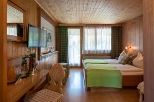 インターラーケンにあるSalzano Basic Rooms Interlakenのベッドとテレビのある寝室 +42枚の写真