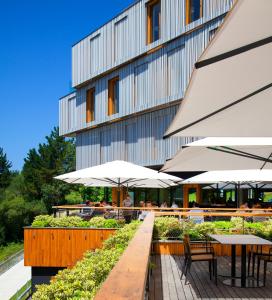 un restaurante con mesas y sombrillas frente a un edificio en Hotel Arima & Spa - Small Luxury Hotels, en San Sebastián