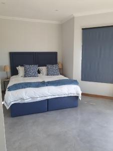 ein Schlafzimmer mit einem großen blauen Bett in einem Zimmer in der Unterkunft Via Lactea in Mmafefe