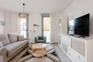 a living room with a couch and a tv at Carmela Suites Apartamento de dos dormitorios in Granada