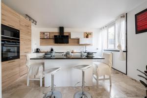 a kitchen with a counter and stools in a room at L'Impressionniste in Pontoise +4 photos