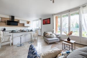 a living room with a couch and a kitchen at L'Impressionniste in Pontoise