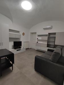 sala de estar con sofá negro y mesa en CASA VACANZE - ANTICO CONVENTO, en Salerno