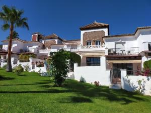 una gran casa blanca con un patio verde en Nerja Sun Apartments Casa Cipreses 6, en Nerja