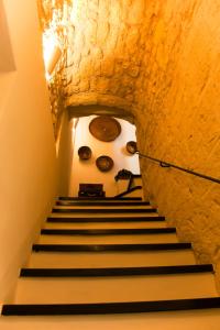 a staircase in a building with a stone wall at Locanda Carra Manna in Sassari