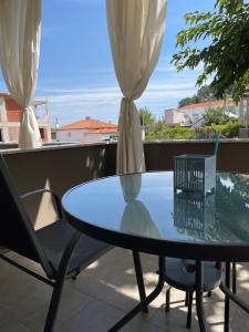 a glass table and chairs on a balcony at Annmari Studios in Skala Potamias