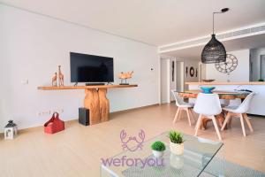 salon z telewizorem, stołem i krzesłami w obiekcie weforyou Sea Views Fuengirola 5 Wave w mieście Fuengirola